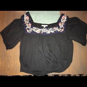 A dark grey shirt with flowers trim